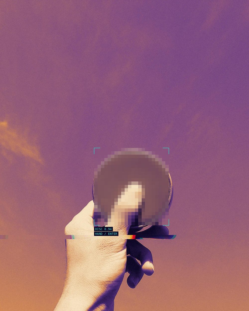A hand holding up a small disc, marked by a pixelated detection patch