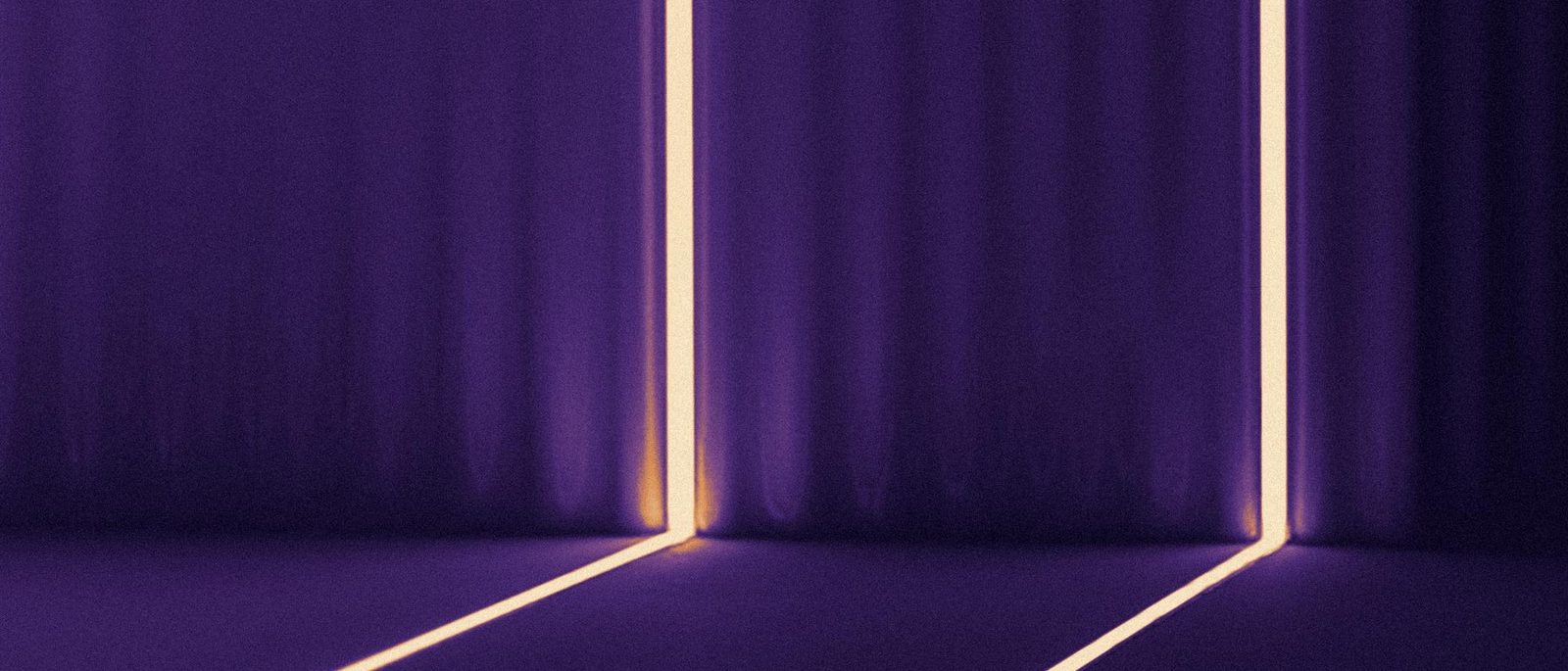 Two lines of light cut into a dark wall and floor